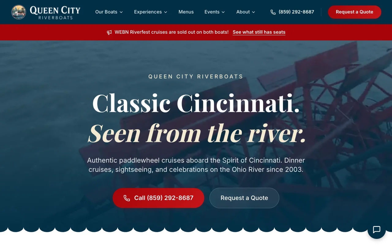 The Spirit of Cincinnati paddlewheeler and the Destiny yacht under the Roebling Suspension Bridge with the Queen City Riverboats and Destiny Yacht Charters logos